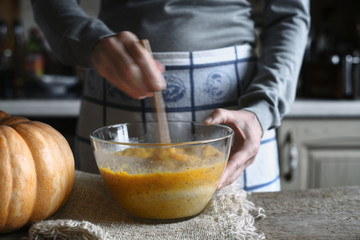 Mixing dough for pumpkin dump cake in the glass bowl horizontal