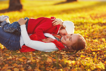 Wall Mural - happy family: mother and child little daughter play cuddling on