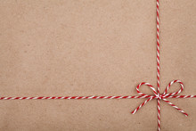 Christmas String Or Twine Tied In A Bow On Kraft Paper Backdrop