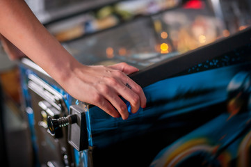 Young woman playing on the pinball machine