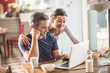© jackfrog - A couple using a laptop while having breakfast in the kitchen