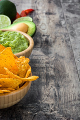 Wall Mural - Nachos, guacamole and ingredients on wooden table

