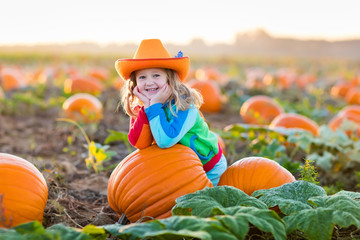 child playing on pumpkin patch