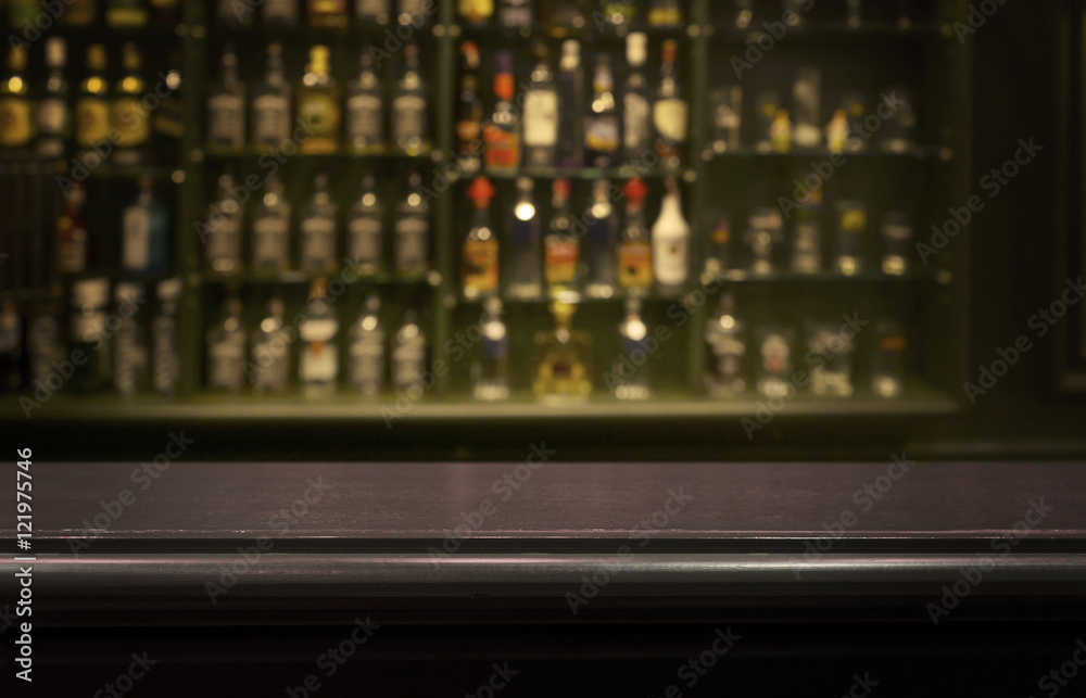 Empty wood counter  bar  table with  blur  bottle background. - obrazy, fototapety, plakaty 
