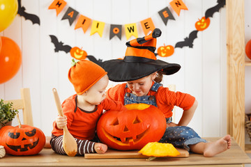 Wall Mural - happy children cut a pumpkin for Halloween