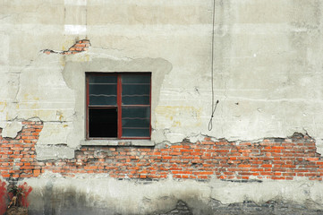 close up on damaged wall of old building with windows