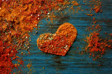 Wall Mural - Different spices in heart shape on wooden background