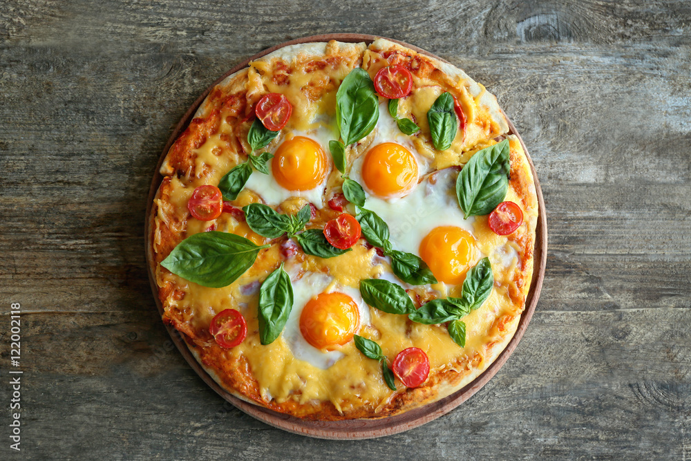 Margarita pizza with basil leaves and egg on wooden background