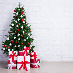 Wall Mural - Decorated christmas tree with colorful balls and gift boxes over