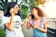 © Flamingo Images - Laughing female friends listen to music