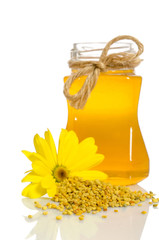 The jar of honey near a pile of pollen and flower isolated on wh