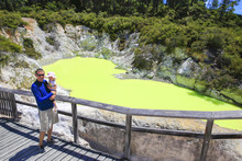 Young Tourist With A Child. Devil's Bath Pool In Waiotapu Therma