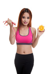 Wall Mural - Asian healthy girl on diet with orange fruit and measuring tape.