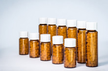 Close-Up Of Medicines In Bottle Against White Background