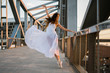 © Kike Arnaiz/ADDICTIVE STOCK - Attractive ballerina in white dress on metal construction