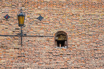 The viewing window and the lamp on the brick wall of the Kolomna Kremlin. A fragment of architecture