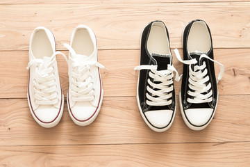 Two pairs of canvas shoes on a wooden