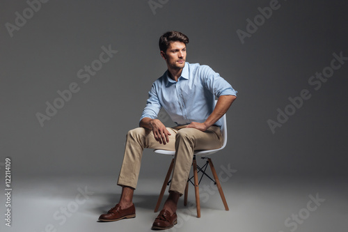 Fotografie, Obraz Pensive brunette man in blue shirt sitting on the chair