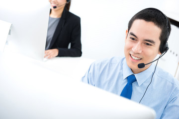 Young Asian businessman working as an operator in call center