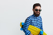 © kegfire - bearded hipster in checkered shirt holding yellow skateboard