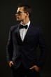 © petrdlouhy - Young businessman in suit on gray background with sunglasses