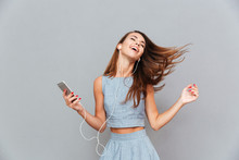 Happy Carefree Woman Dancing And Listening To Music From Smartphone