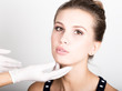 © sandyche - beautician hand's examining beautiful young female face.