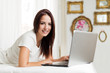 © Tijana - Beautiful woman using a laptop in a bright room