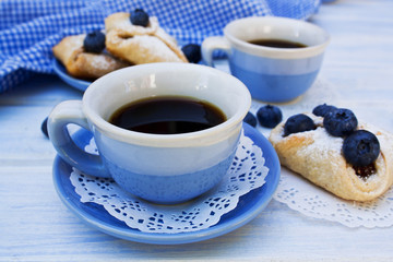 two cups of coffee with cookies and blueberry