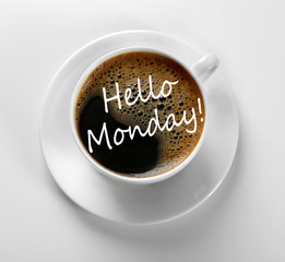 Canvas Print - Text HELLO MONDAY and cup of aromatic coffee on white background, closeup