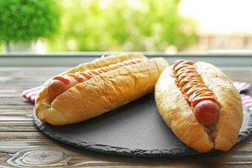 Canvas Print - Tasty hot dogs on round wooden board