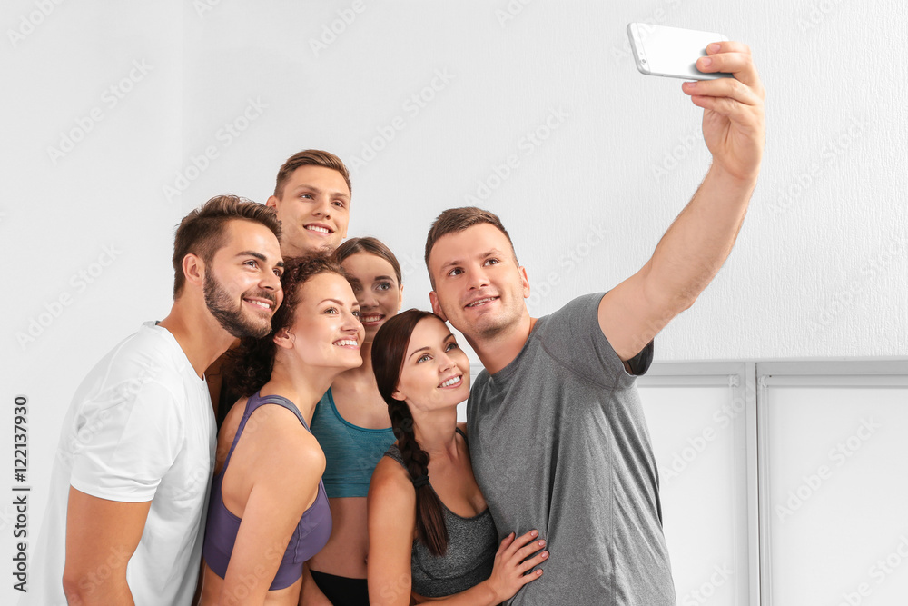Sport concept. Group of people taking selfie in gym