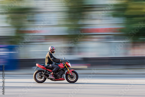Motorcycle rider in the city traffic in motion blur Poster