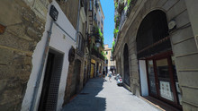 BARCELONA CATALONIA SPAIN - JULY 2016: Smooth Camera Steady Shot Along Narrow Street In The Center Of Barcelona, Near To Gothic Quarter, Clear Blue Sky With Sun Shining, Tourists Slowly Walking Along