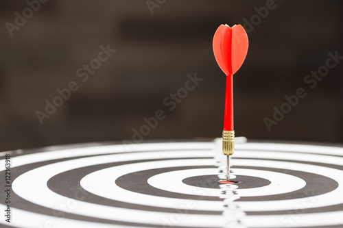 Fotografía Target dart arrow hitting in the target center of dartboard