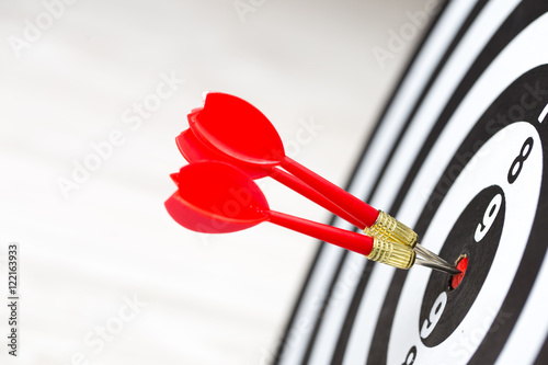Fotografía Target dart arrow hitting in the target center of dartboard