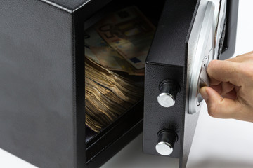 Man's hand opening the door of a safe deposit box