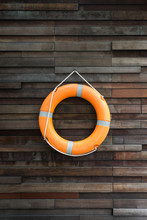 Safety First - Orange Lifebuoy Hanging On Brown Wooden Wall 