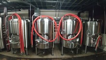 Stainless Steel Tanks With Hoses In Brewery