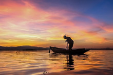 Silhouette Fisherman On Fishing Boat Setting Net With Sunrise