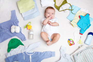 Baby on white background with clothing, toiletries, toys and health care accessories. Wish list or shopping overview for pregnancy and baby shower.

