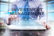 © WrightStudio - Businessman is using tablet computer, pressing button on touch screen and selecting 'Investment management'.