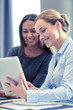 © Syda Productions - smiling businesswomen with tablet pc in office