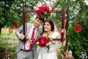 Wedding portrait. Bride and groom smiling and posing with frame. Red wedding