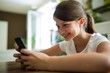 © WavebreakMediaMicro - Girl using mobile phone in the living room