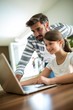 © WavebreakMediaMicro - Father and daughter using laptop in the living room