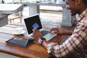 Poster - Man doing online shopping with credit card on laptop