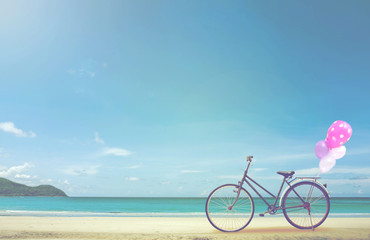 vintage bicycle on white sand beach over blue sea and clear blue sky background, spring or summer holiday vacation concept.
