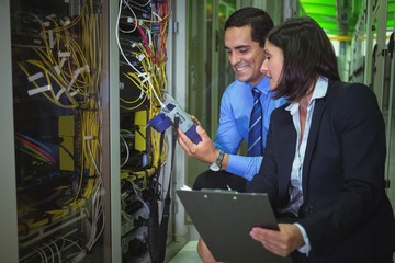 Aufkleber - Technicians using digital cable analyzer while analyzing server