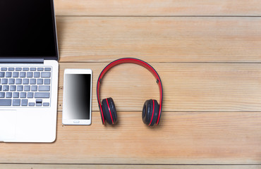 smartphone ,laptop with wireless headphones on wooden background. Top view. Modern life - musical entertainment. Listen to music. Communication.